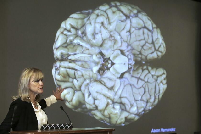 FILE - In this Thursday, Nov. 9, 2017 file photo, Ann McKee, director Boston University's center for research into the degenerative brain disease chronic traumatic encephalopathy, or CTE, addresses an audience on the school's campus about the study of NFL football player Aaron Hernandez's brain, projected on a screen behind in Boston. According to a new public service announcement, signing a pre-teen child up for tackle football is like teaching him to smoke. The ad from the Concussion Legacy Foundation encourages parents to choose flag football for children younger than 14. (AP Photo/Steven Senne, File)
