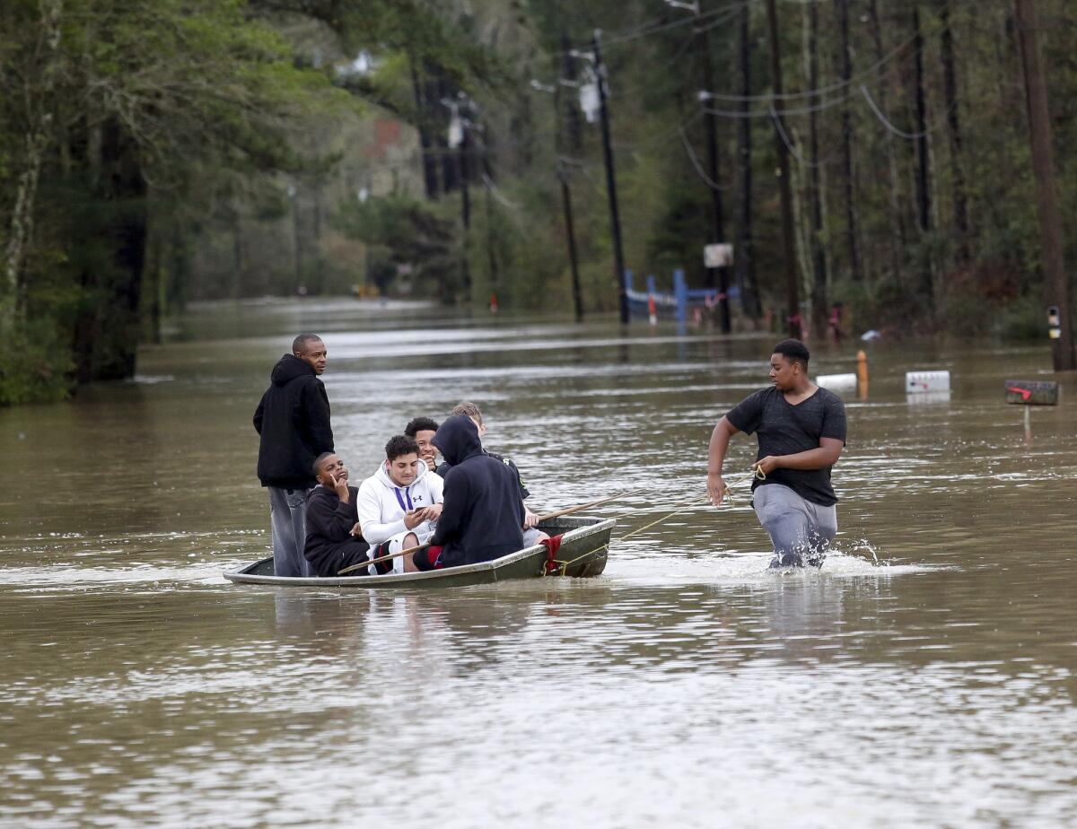 Zavion Watson pulls a boat full of people to dry land as they evacuate their homes.