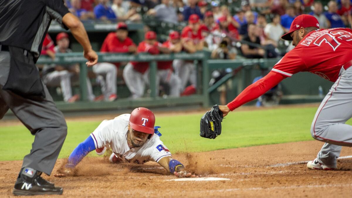 Texas Rangers' Robinson Chirinos scores ahead of the tag of pitcher Osmer Morales (73) on a wild pitch by Morales during the eighth inning.