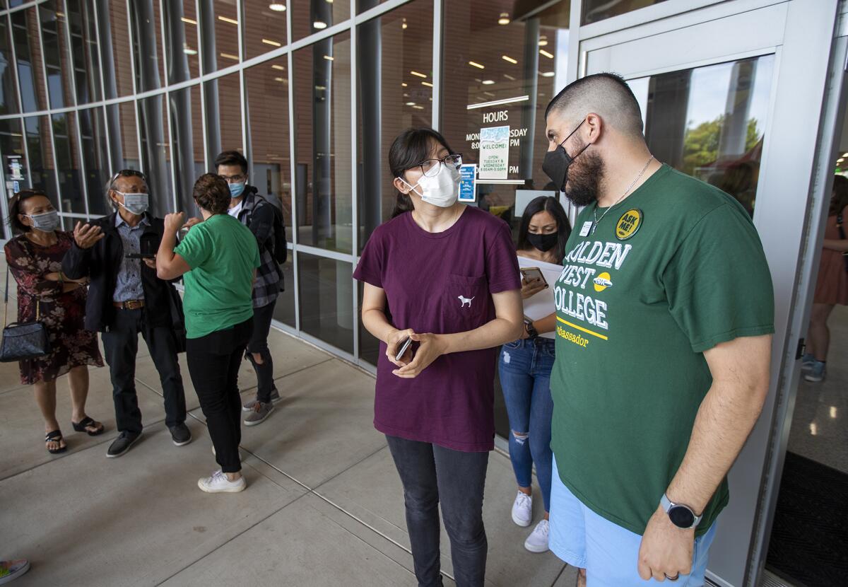 Frank Cirioni, the director of campus life, right, helps incoming freshman Mariela Arroyo. 