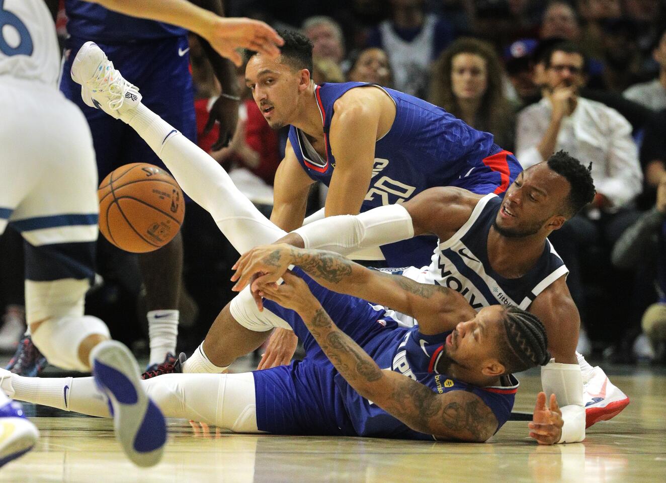 Clippers guard Rodney McGruder, front, recovers the ball during a scrum on the floor with Timberwolves guard Josh Okogie during the second half of a game Feb. 1 at Staples Center.