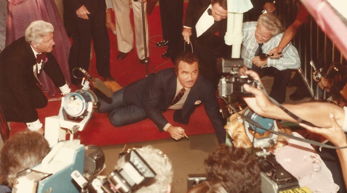 Burt Reynolds prepares to write in wet cement outside the Chinese Theatre in 1981. (TCL Chinese Theatre)