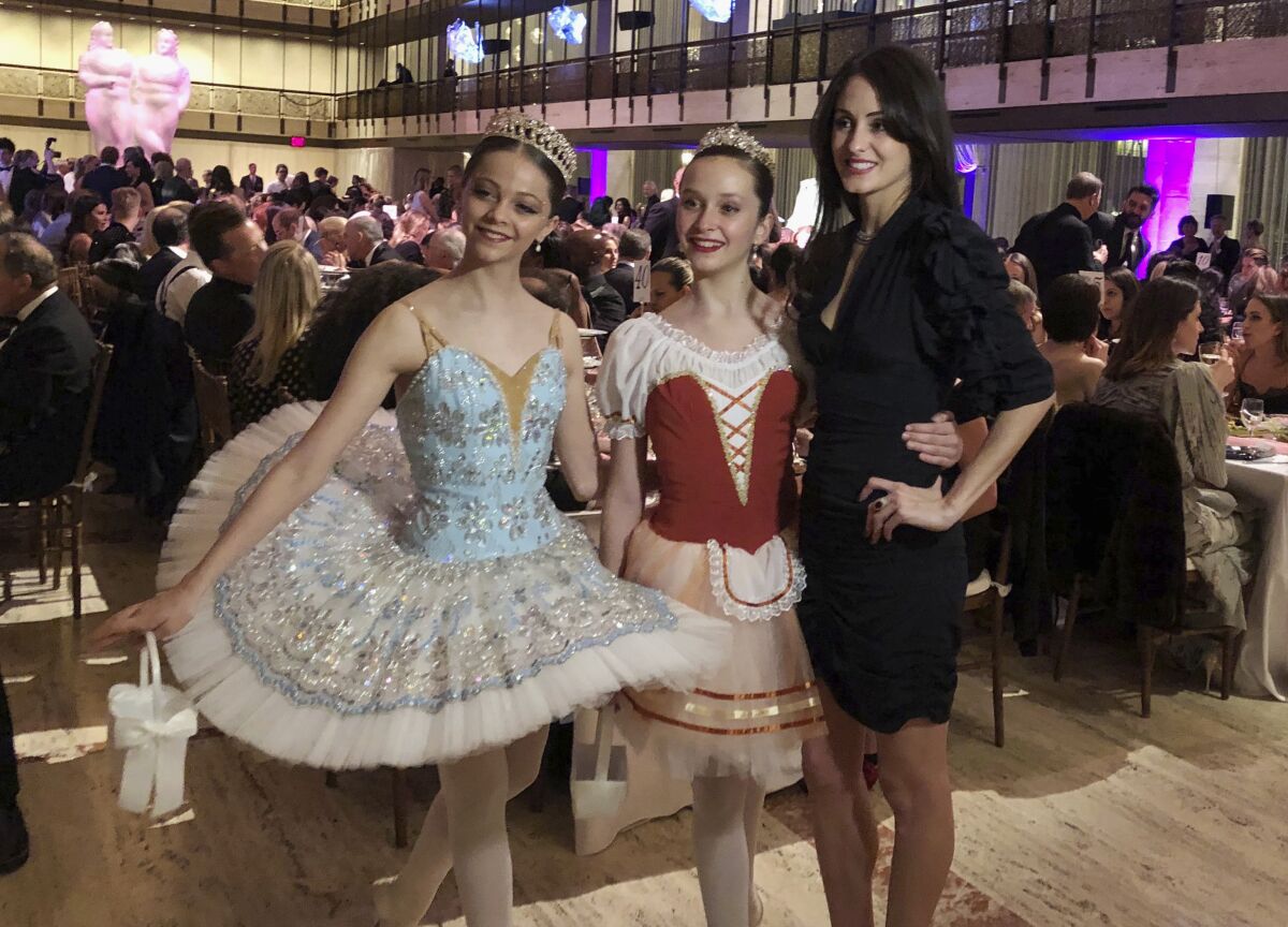 FILE - In this image taken from video, choreographer Melanie Hamrick poses for a photo with young dancers at the gala of Youth America Grand Prix, the world's largest ballet scholarship competition, on April 18, 2019, after the U.S. premiere of her new ballet, "Porte Rouge" (Red Door). Hamrick's Live Arts Global company is producing “A Night at the Ballet,” a free streaming event that premieres this week. The event will treat ballet-starved fans to dancers from America’s top companies performing excerpts of classical ballets like “Romeo and Juliet, “The Nutcracker” and “Don Quixote.” (AP Photo/Aron Ranen, File)