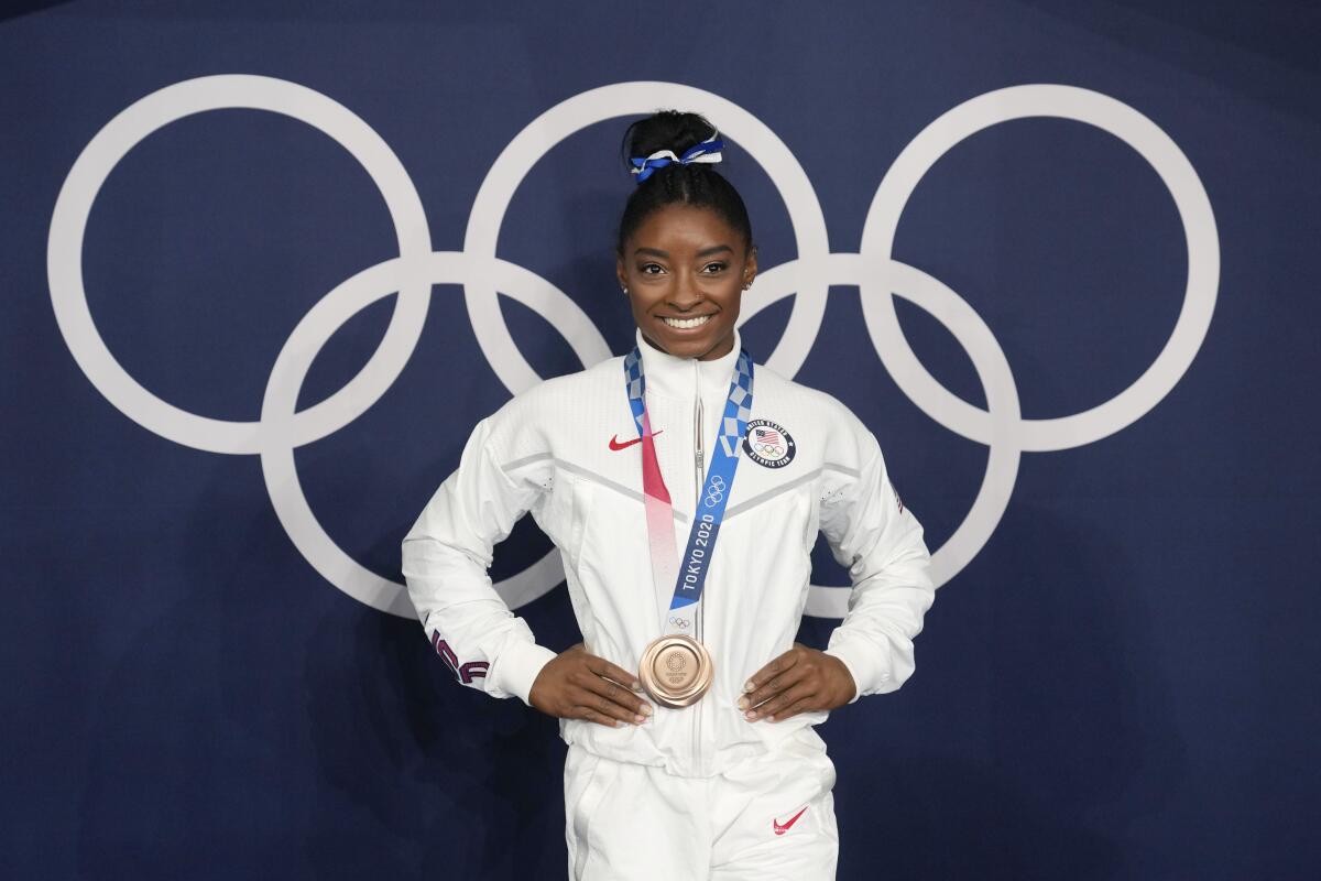 FILE - Simone Biles, of the United States, poses wearing her bronze medal