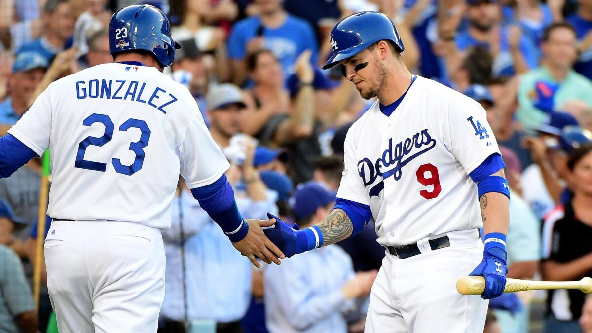 Dodgers catcher Yasmani Grandal (9) congratulates first baseman Adrian Gonzalez after he scored against the Mets in the first inning of Game 5.
