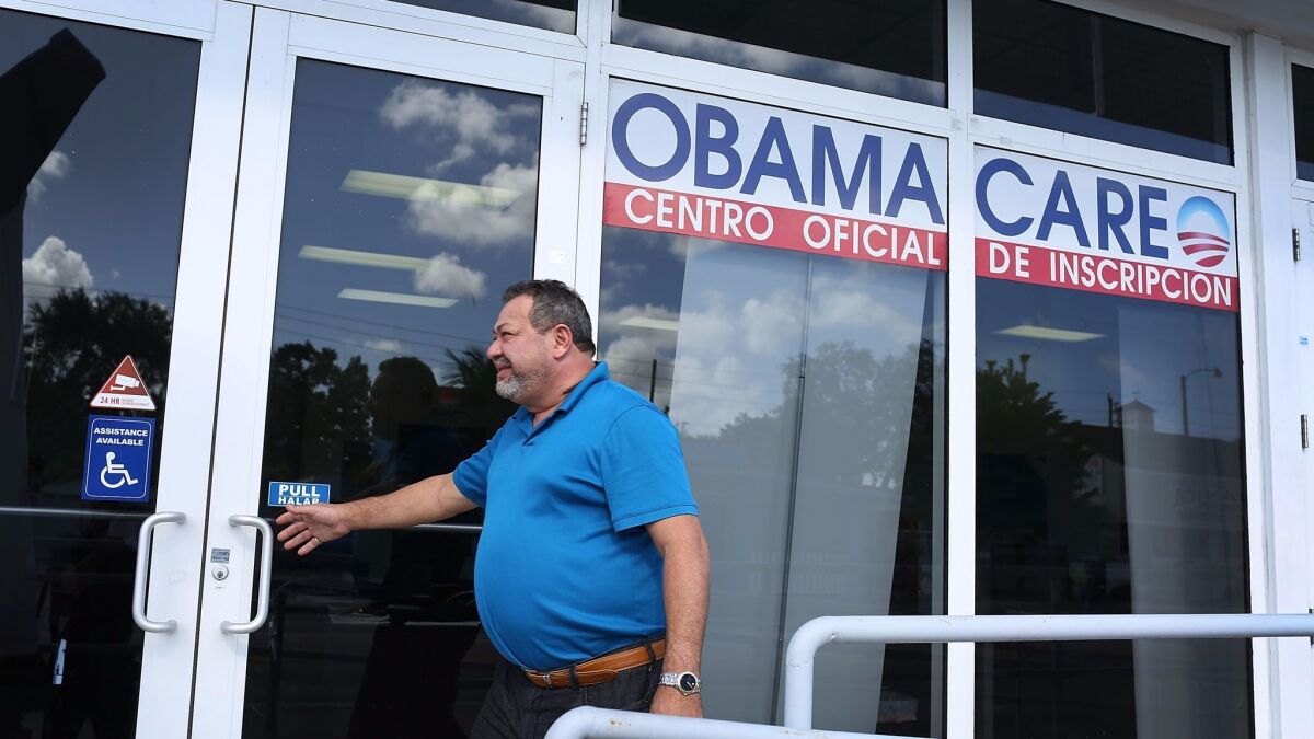 A man walks into an insurance office in Miami where people are signing up for health insurance under the Affordable Care Act,