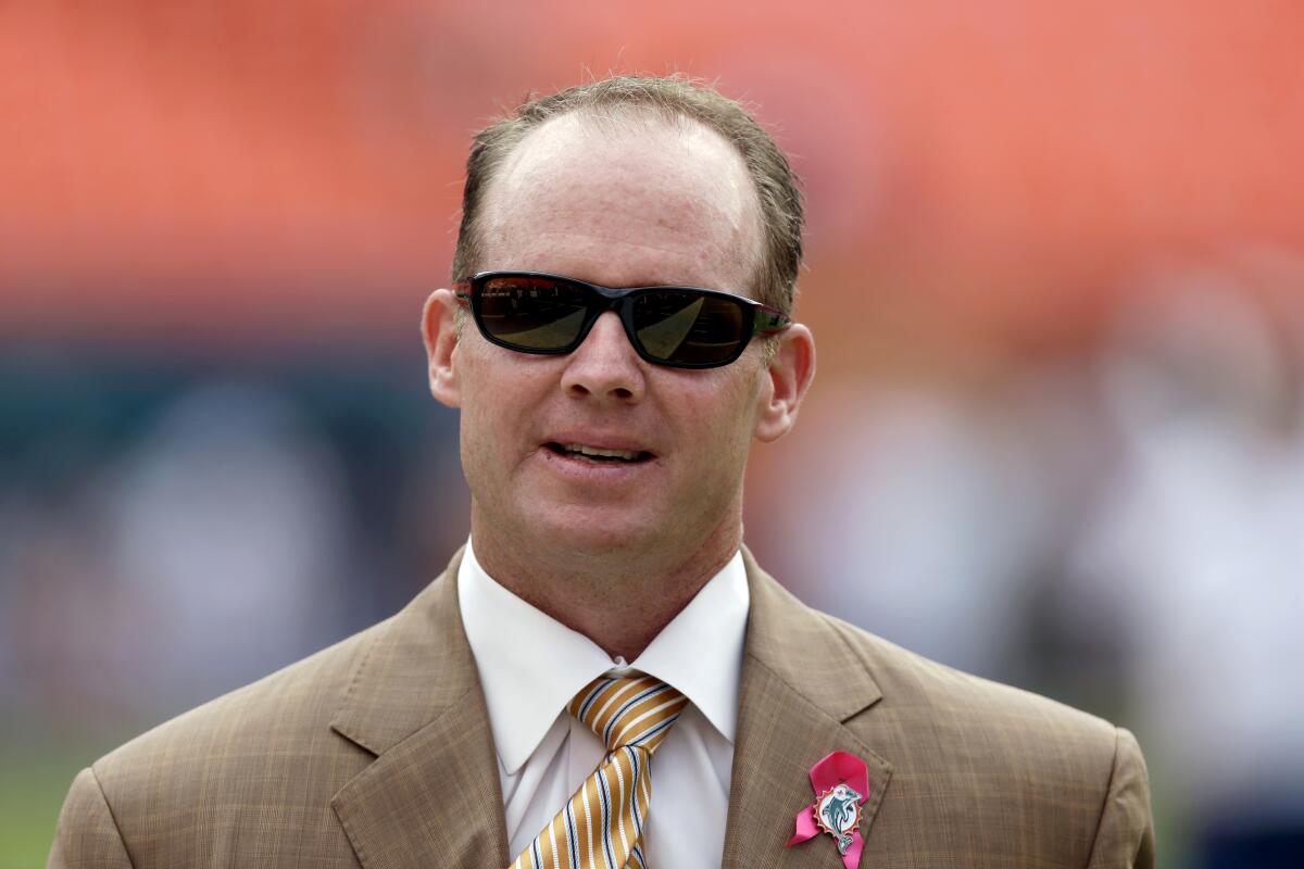 Former Dolphins general manager Jeff Ireland walks the field wearing sunglasses