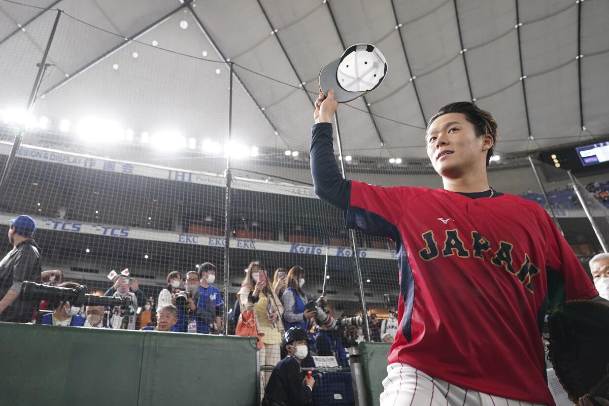 Yoshinobu Yamamoto greets fans before a World Baseball Classic game between Japan and Italy on March 16.