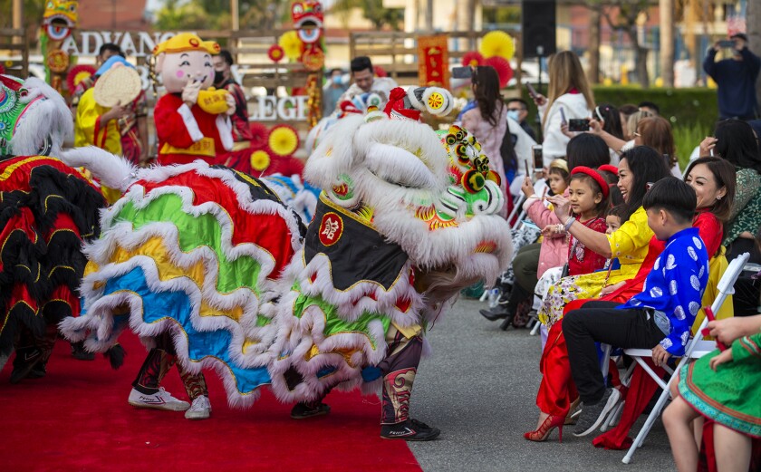 Spectators feed envelopes to a member of the Qing Wei Lion and Dragon Cultural Troupe.