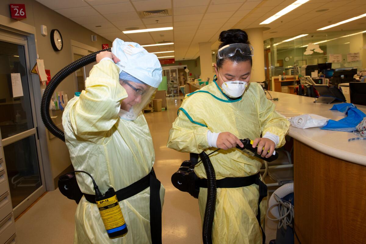 Two nurses suit up in personal protective equipment at EvergreenHealth Medical Center in Kirkland, Wash., on March 14