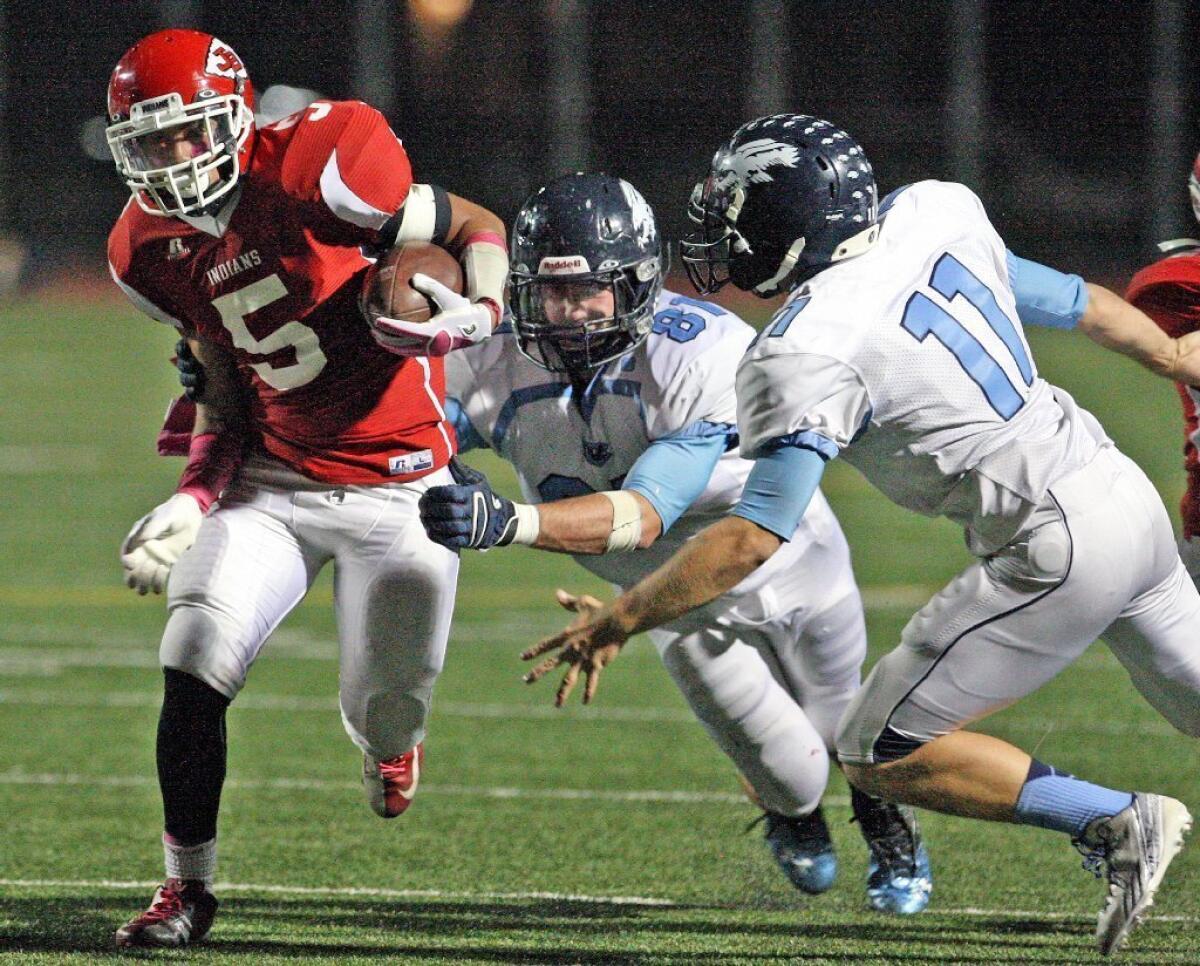 Burroughs' Javier Pineda, from left, tries to evade Crescenta Valley defenders Matt Erickson and Kevin Hello in a comeback 24-17 lead for the Indians.