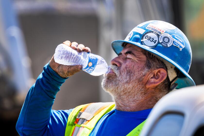 Irvine, CA - September 05: A construction worker takes a water break while digging a trench with a shovel amidst a heat wave in Irvine Thursday, Sept. 5, 2024. (Allen J. Schaben / Los Angeles Times)