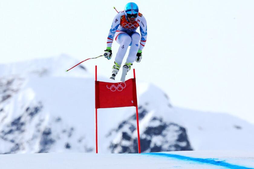 Matthias Mayer catches air as he makes his gold-medal winning run in the men's downhill on Sunday at Rosa Khutor Alpine Center.