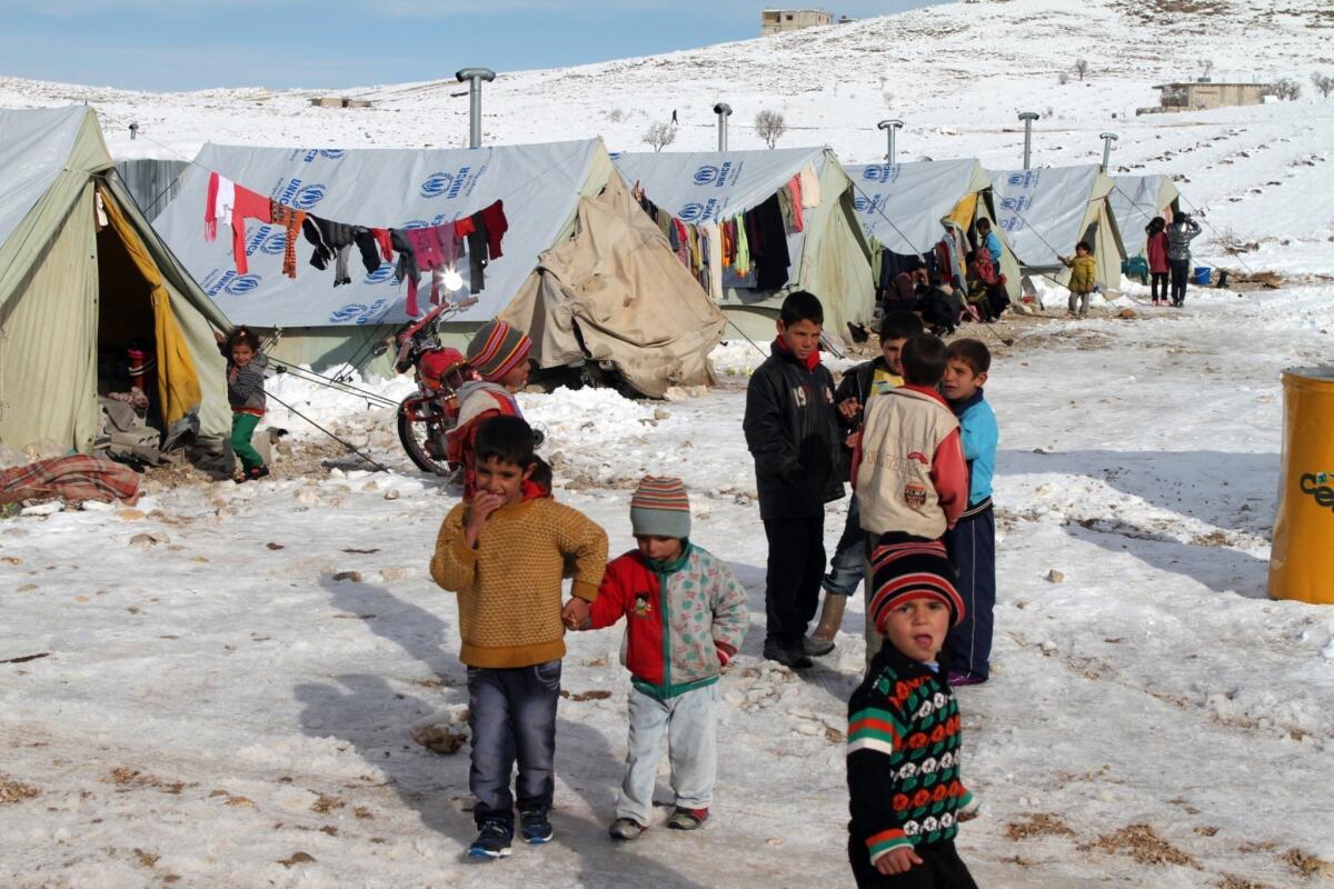 Syrian children stand in the snow in a refugee camp in the town of Arsal in Lebanon's Bekaa Valley.