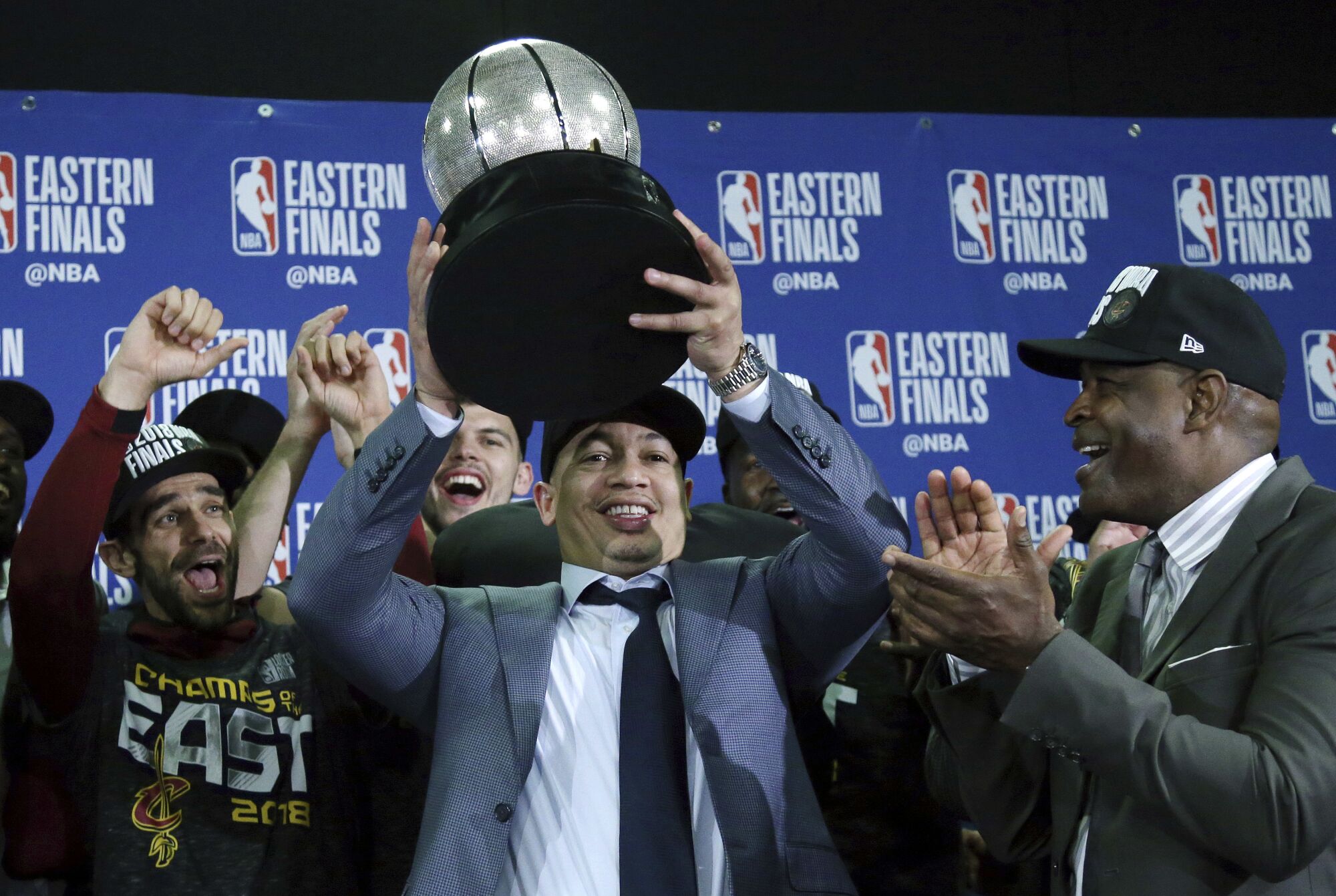 Tyronn Lue, with friend and assistant coach Larry Drew to his right, hoists Eastern Conference trophy after beating Boston.