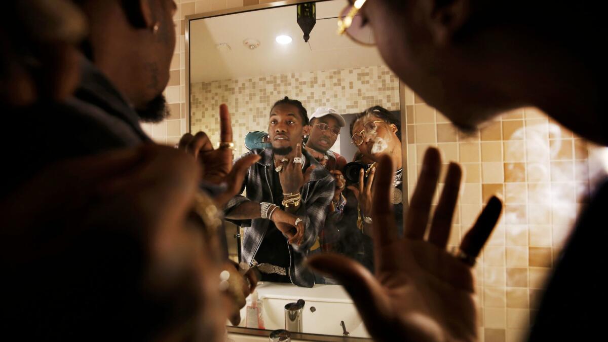 The hip-hop trio Migos looks in the mirror before their show at the Novo in L.A. on Jan. 18. From left: Offset, Quavo and Takeoff. https://lat.ms/2kNLJ8m