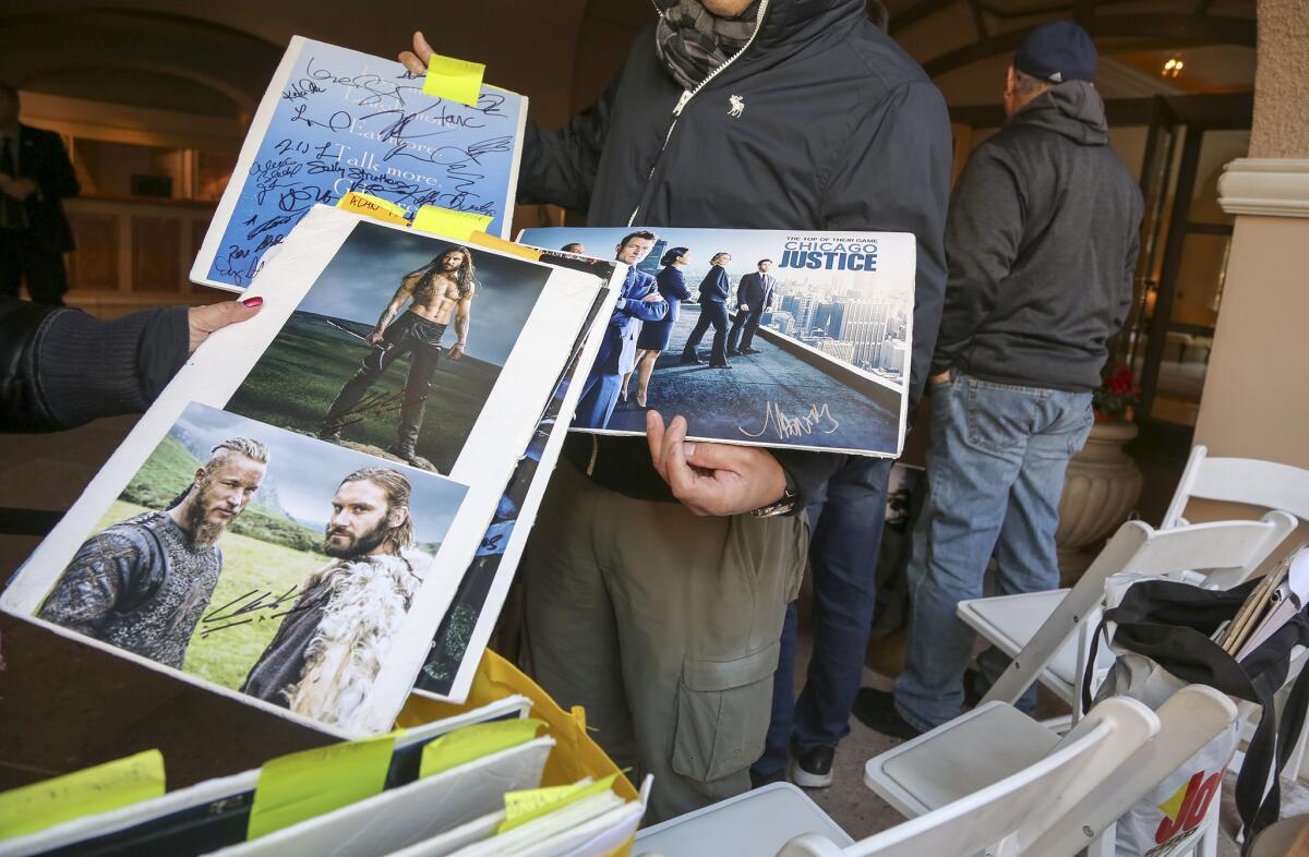 Autograph hunters, or "graphers," show some of their prized possessions while waiting for stars at the Television Critics Assn.'s winter press tour on Jan. 18.