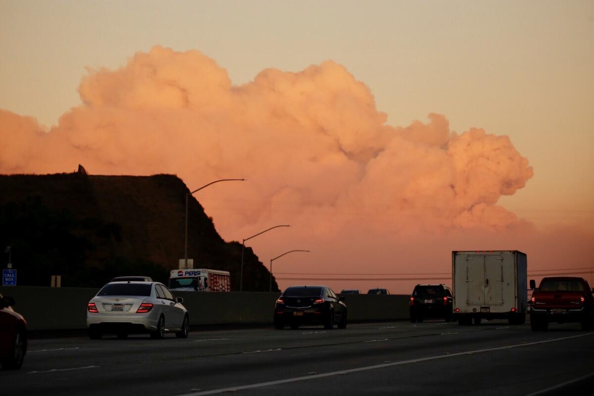 A towering cloud of smoke from the Thomas fire looms before drivers on the 101 Freeway at the Conejo Grade in Ventura County.