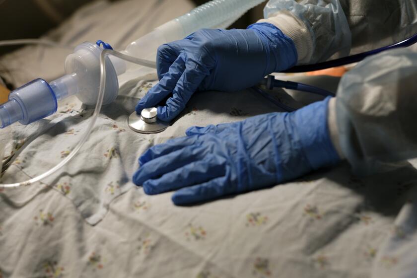 TORRANCE, CA - AUGUST 05: Dr. Anita Sircar, MD, uses her stethiscope as she examines a covid19 positive patient inside Little Company of Mary Medical Center on Thursday, Aug. 5, 2021 in Torrance, CA. "The greatest weapon that we have right now is the vaccine. And people aren't getting it," Dr. Anita Sircar said. COVID-19 cases have been on the rise again in Los Angeles County, powered by the highly contagious Delta variant of the virus, the loosening of some pandemic restrictions, and halting progress in vaccination. (Francine Orr / Los Angeles Times)