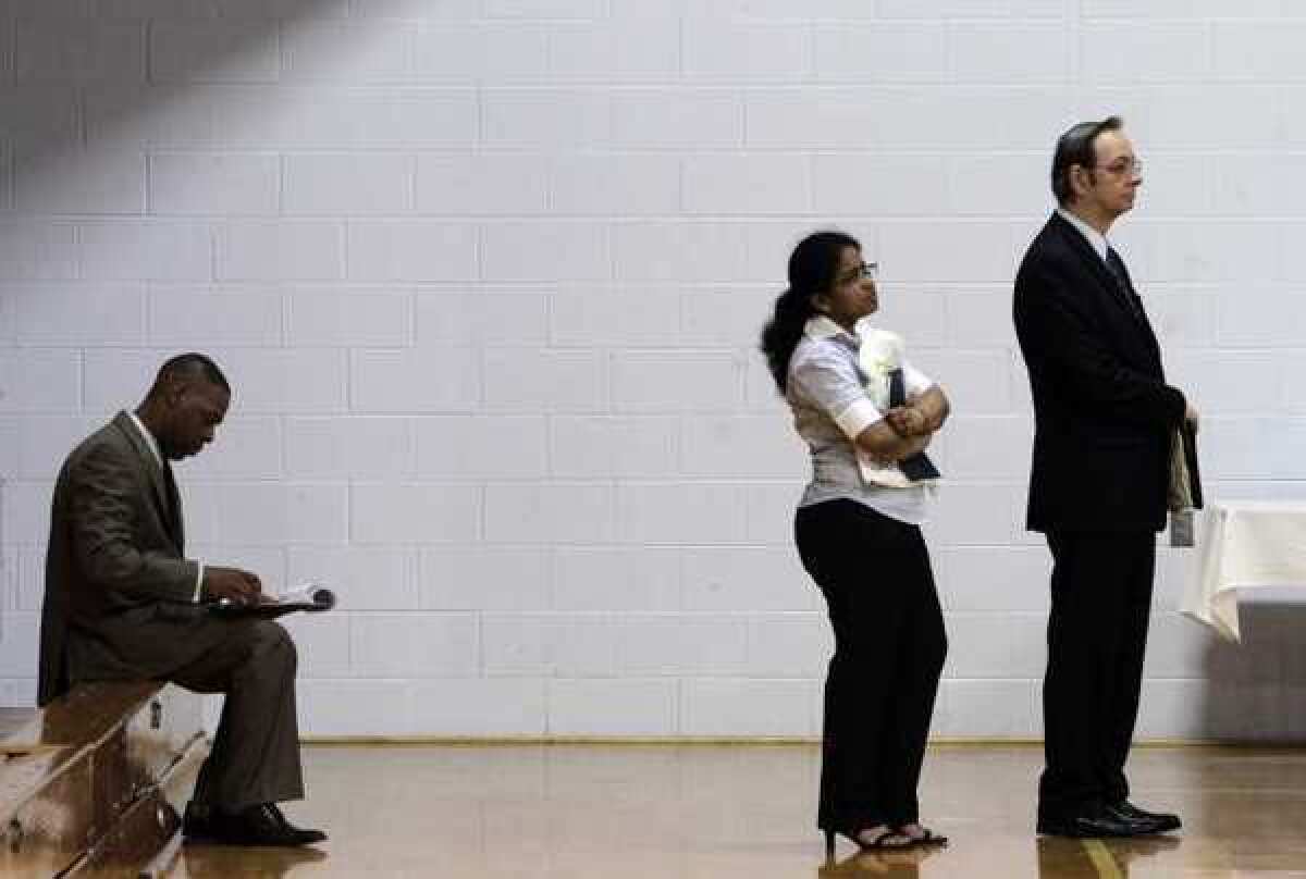 Job-seekers wait in a line at a job fair in Southfield, Mich., in 2011.