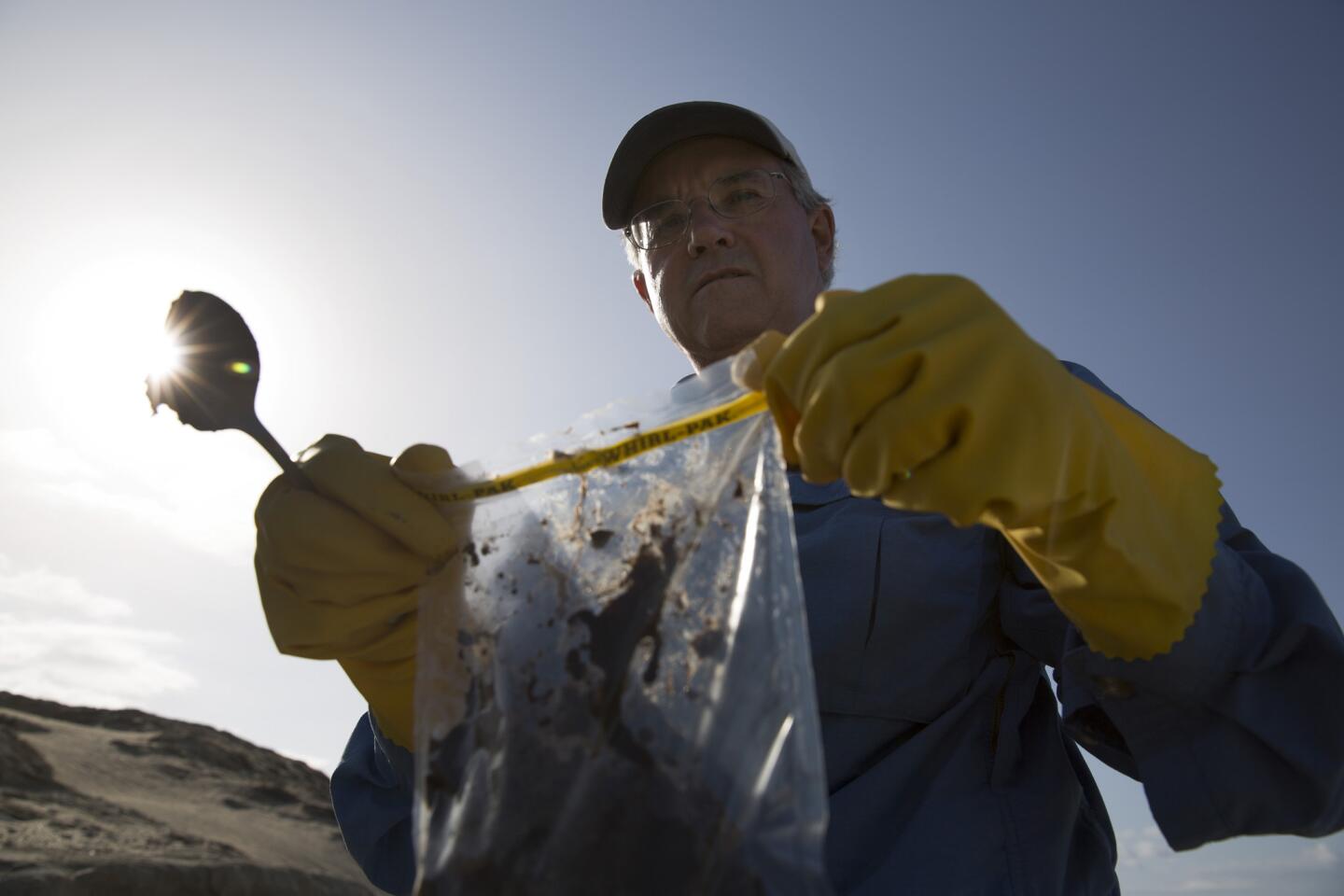 Biologist Mark Lowry uses a large tablespoon to scoop up sea lion and elephant seal scat to track the long-term health of marine mammal life on San Nicolas Island.