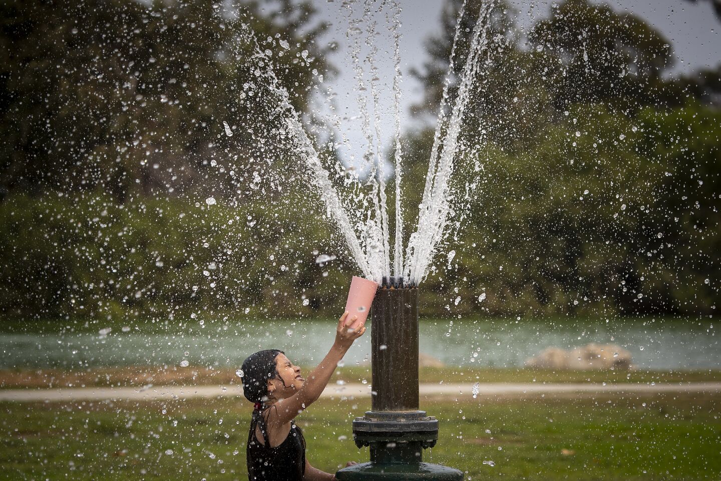 Laura Martinez, 8, of Santa Ana cools off at Mile Square Park in Fountain Valley.