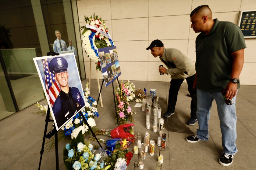 Chris Martin and Ricardo Camacho, friends of slain LAPD Officer Juan Diaz, visit a memorial for Diaz outside LAPD headquarters.