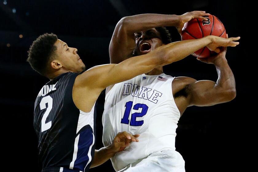 Duke forward Justise Winslow tries to power his way past Gonzaga forward Angel Nunez during Blue Devils' 66-52 victory over the Bulldogs on Sunday in the South Regional final in Houston.