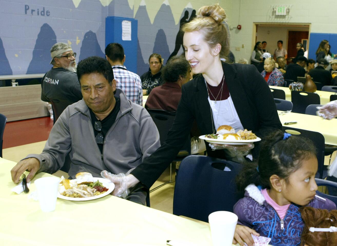 Volunteer Chelsea Giegerich serves a Thanksgiving dinner to Eduardo Contreras of Glendale at the Glendale Salvation Army's annual Thanksgiving Day dinner, at the Windsor Road location, in Glendale on Thursday, Nov. 24, 2016. More than 150 people were served turkey, mashed potatoes and gravy, vegetables, pie and drinks in the first hour. The location was expecting about 350 people to come for dinner.