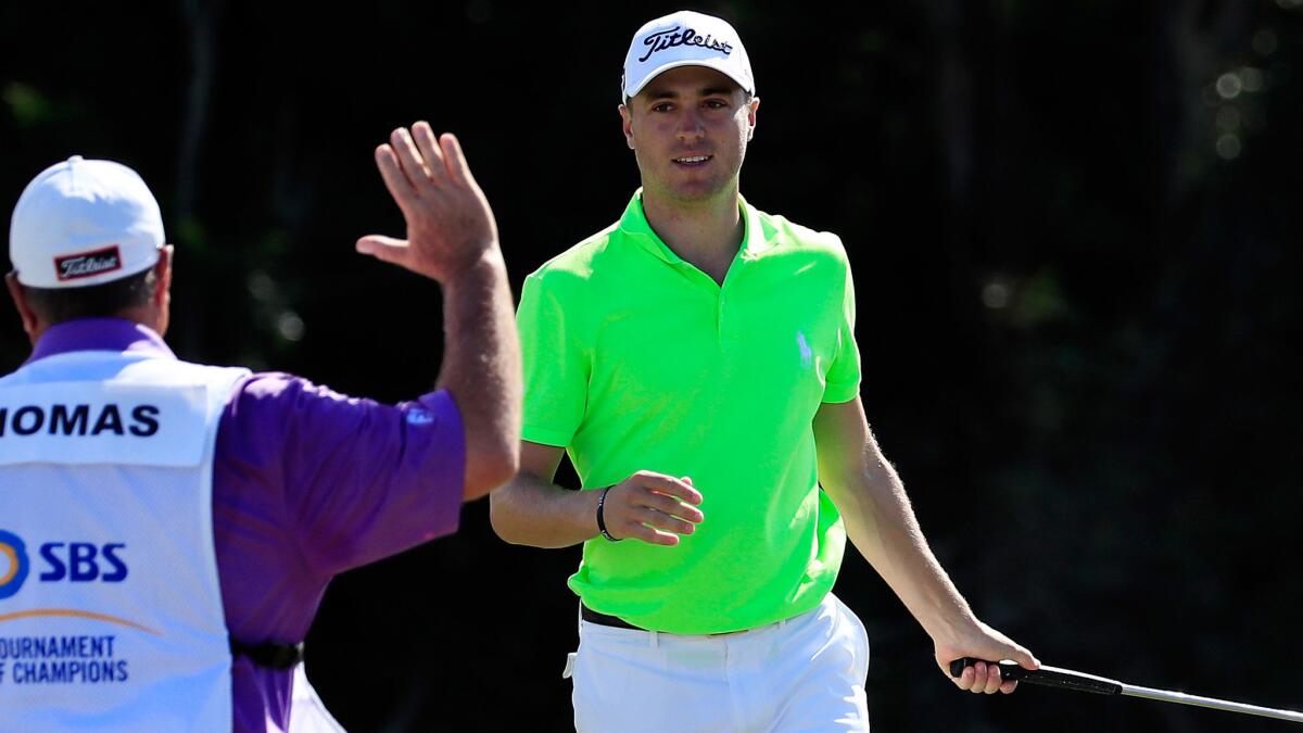 Justin Thomas celebrates with caddie Jimmy Johnson after winning the Tournament of Champions on Sunday.