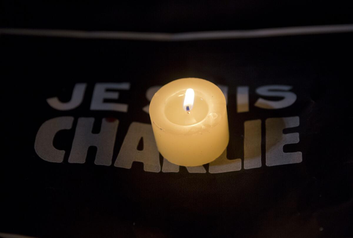 A candle burns on a sign that reads in French "I am Charlie" for those killed in an attack at the Paris office of the weekly satirical newspaper Charlie Hebdo.