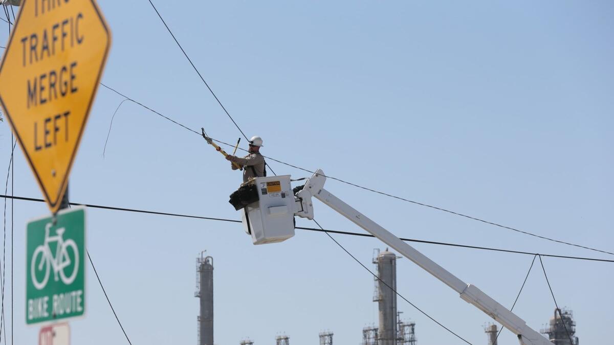 A Southern California Edison employee repairs a power line in 2013. The utility this week was fined $8 million by the California Public Utilities Commission in connection to an incident that injured three Marines in Twentynine Palms in 2015.