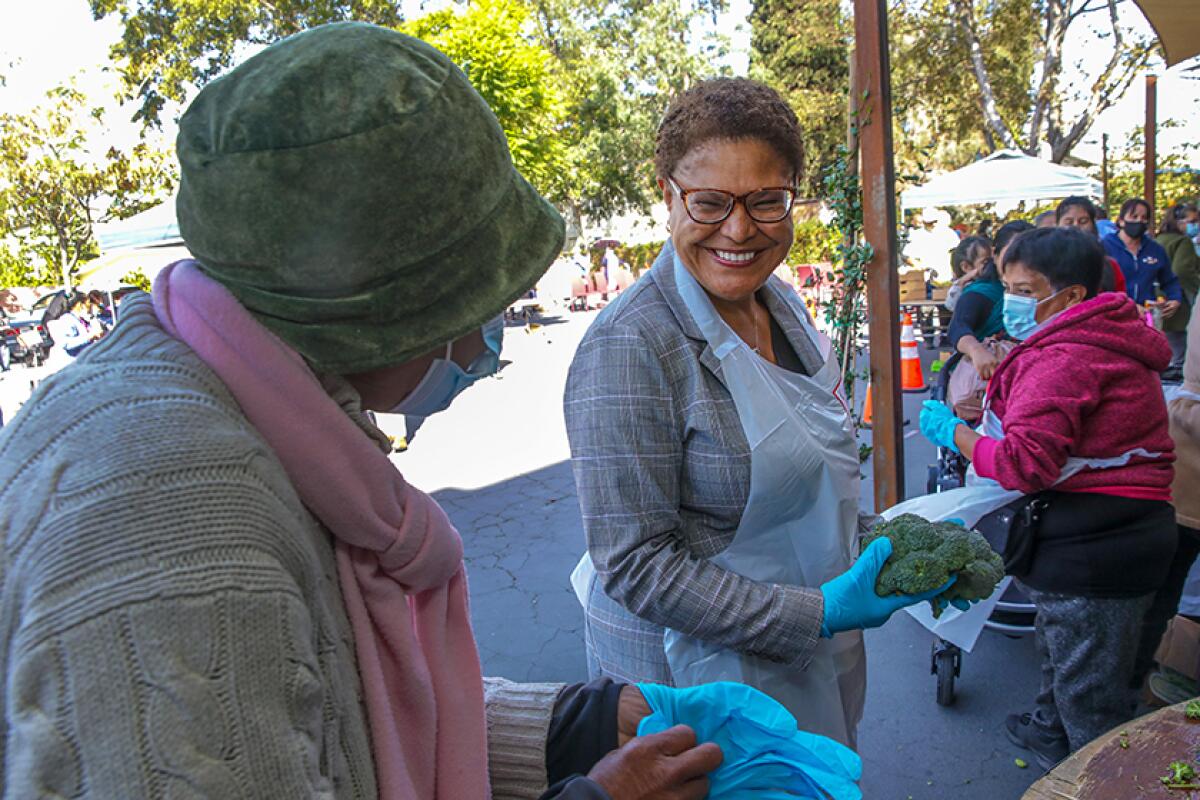 L.A. mayoral candidate Karen Bass distributes produce at a farmers market at Pico Union Project on Friday.