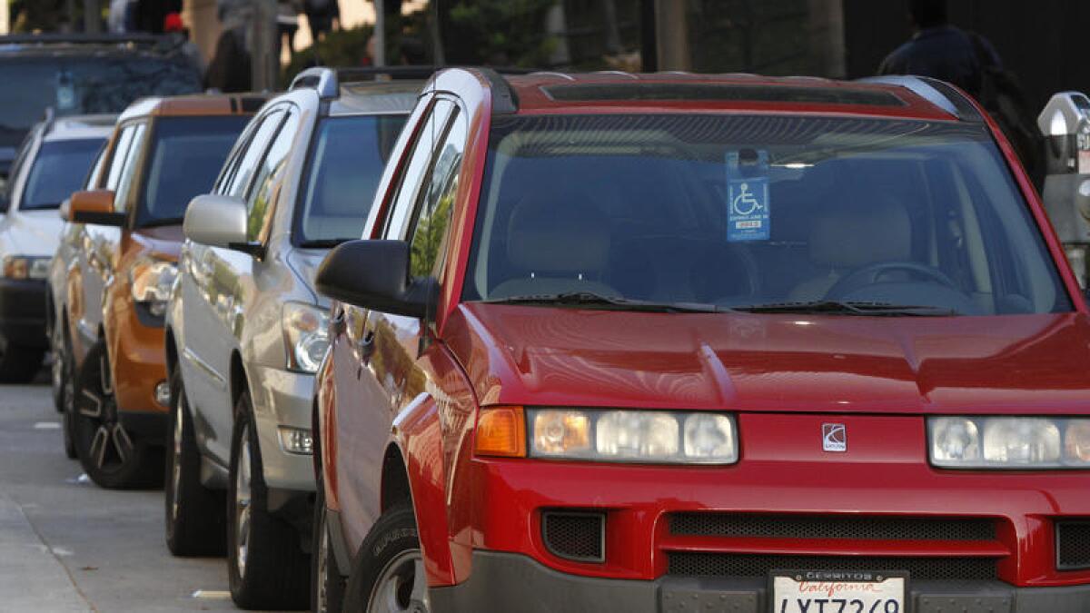 Una fila de automóviles que muestran los carteles para personas con discapacidad están estacionados cerca de las calles 4th y Hill en el centro de Los Angeles el 10 de febrero del 2012.