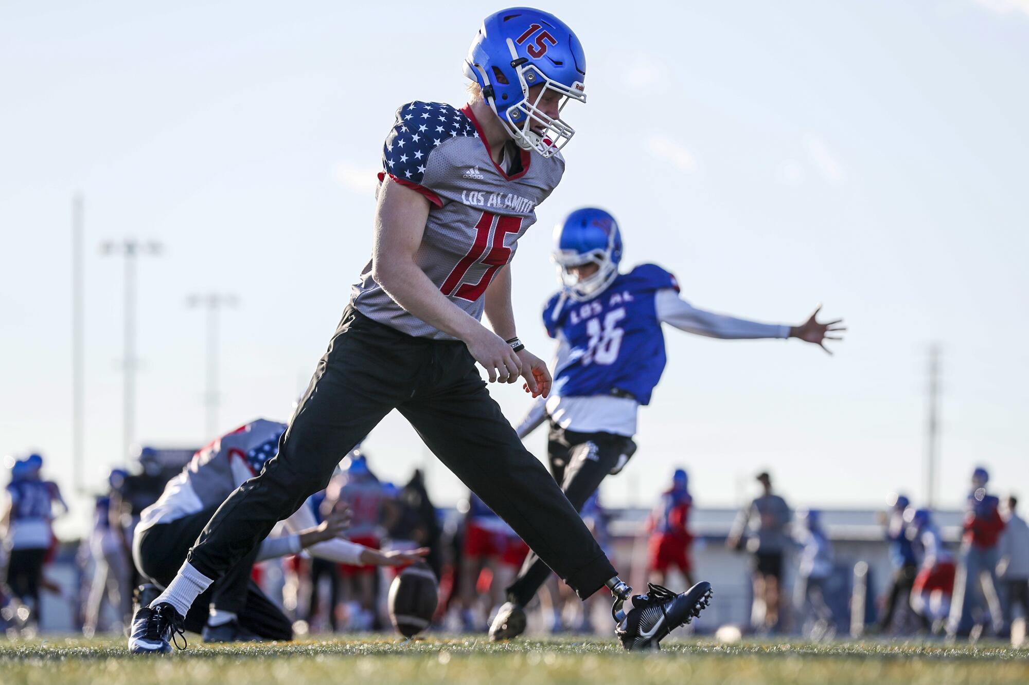 Los Alamitos long snapper Carson Fox walks on a football field with a prosthetic leg.