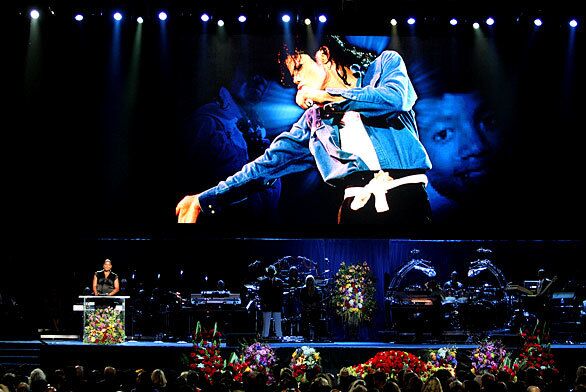 Queen Latifah, left, speaks under a huge image of Michael Jackson during a memorial at Staples Center in Los Angeles.