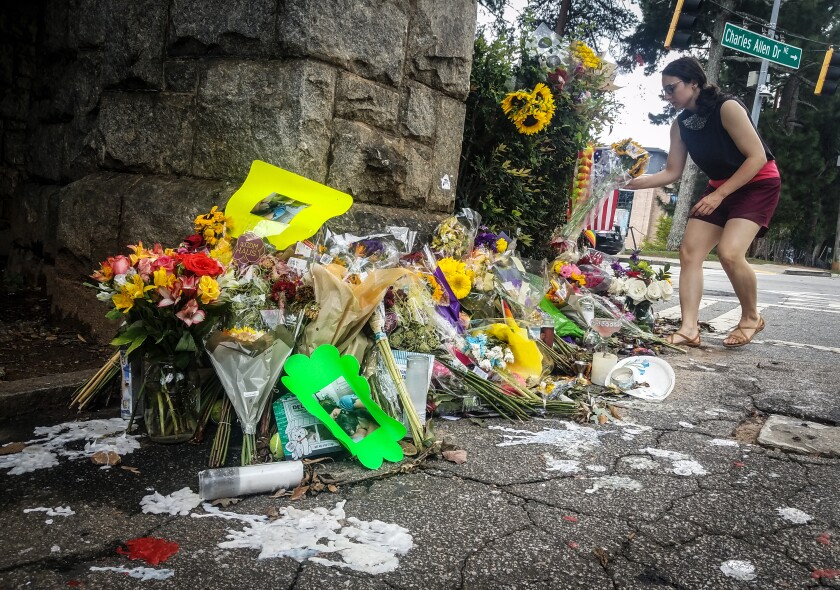 A makeshift memorial to Katherine Janness is seen at the entrance to Piedmont Park on Sunday, Aug. 1, 2021, in Atlanta. Janness, 40, was found stabbed to death in the park in the early hours of July 28. Police say her dog was also killed at the scene. No arrests have been made and the FBI is assisting local authorities in the case. (AP Photo/Ron Harris)
