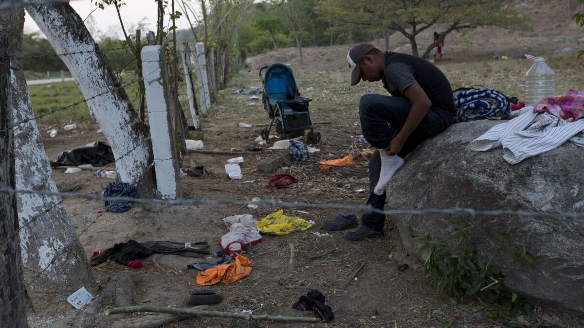 A migrant puts on the socks he'd left behind April 22 when his group ran and hid from Mexican immigration agents in Pijijiapan, Chiapas state.