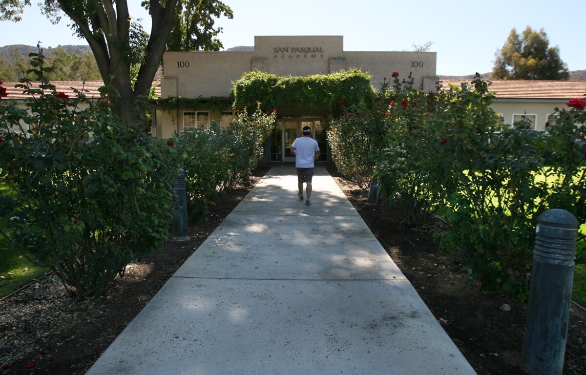 A person walks toward the main entrance to San Pasqual Academy.
