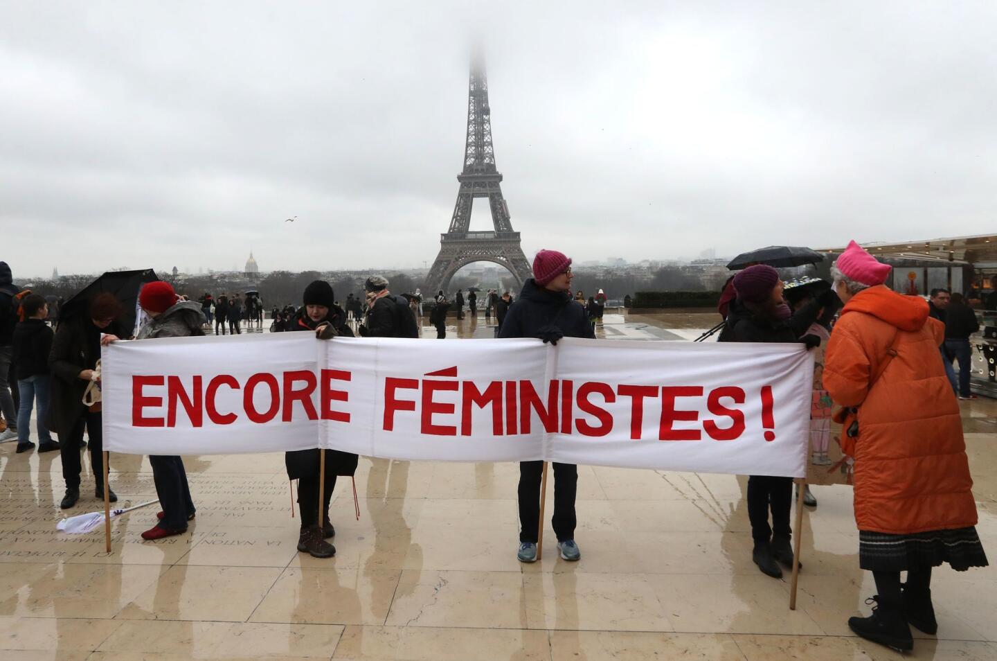 Women hold a banner reading "still feminist" with the Eiffel tower in background on the Trocadero esplanade in Paris on Jan. 21, 2018, during a women's march organized as part of a global day of protests, a year to the day since Donald Trump took office as US president.