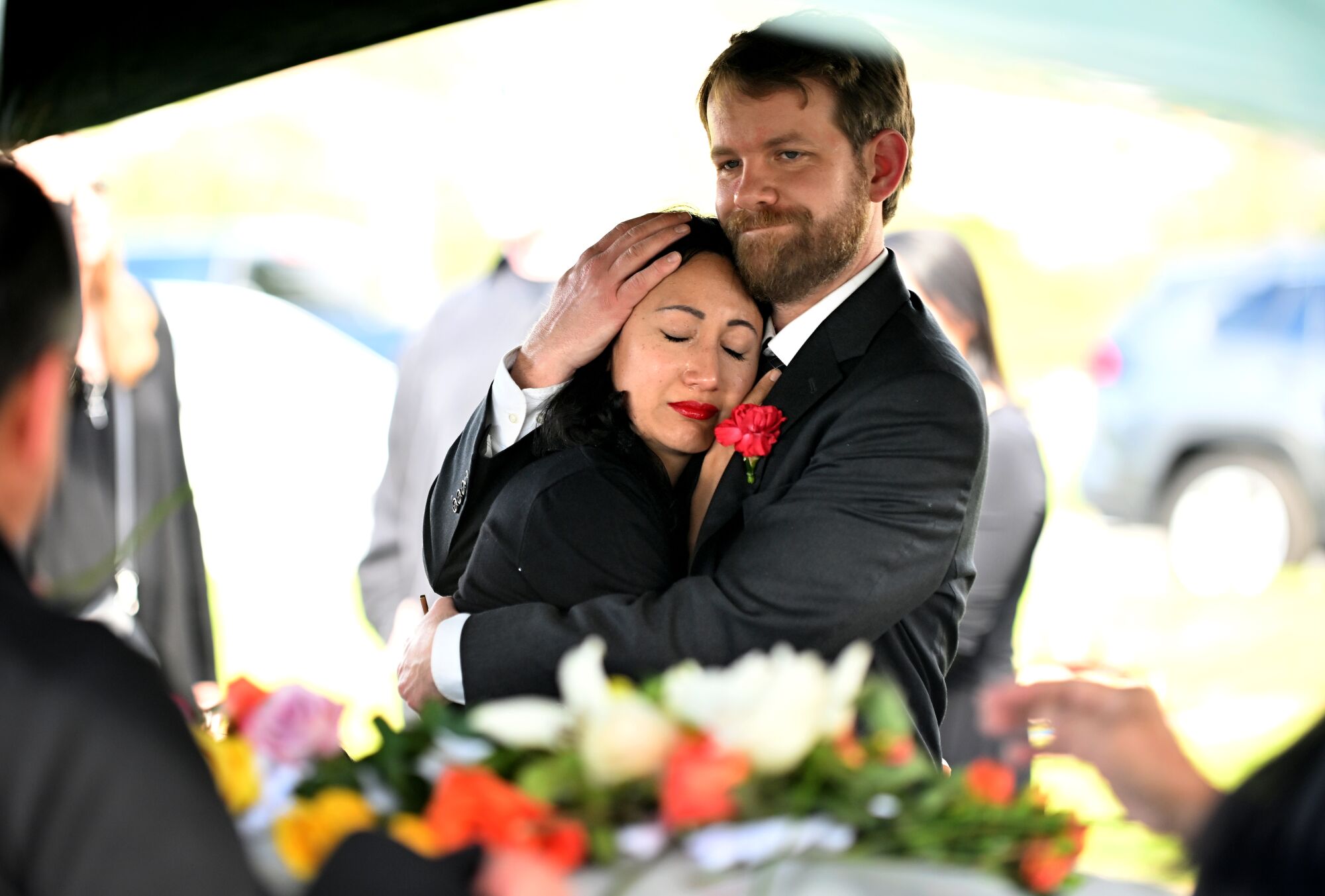 Kristenne Reidy is held by her husband Skyler near the casket 