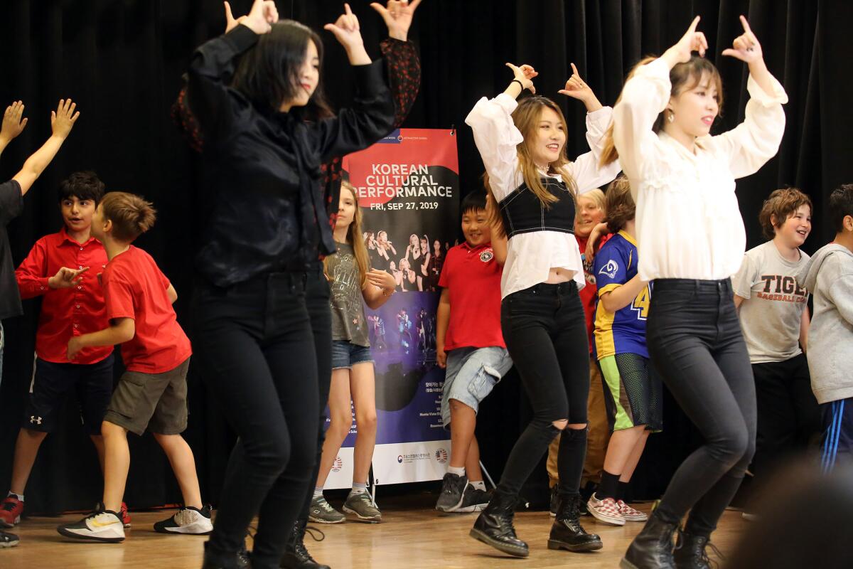 The Minnesota K-Pop Dance Crew invite the dual-immersion Korean-language students on stage to dance with them during a performance at Monte Vista Elementary School in La Crescenta on Friday.