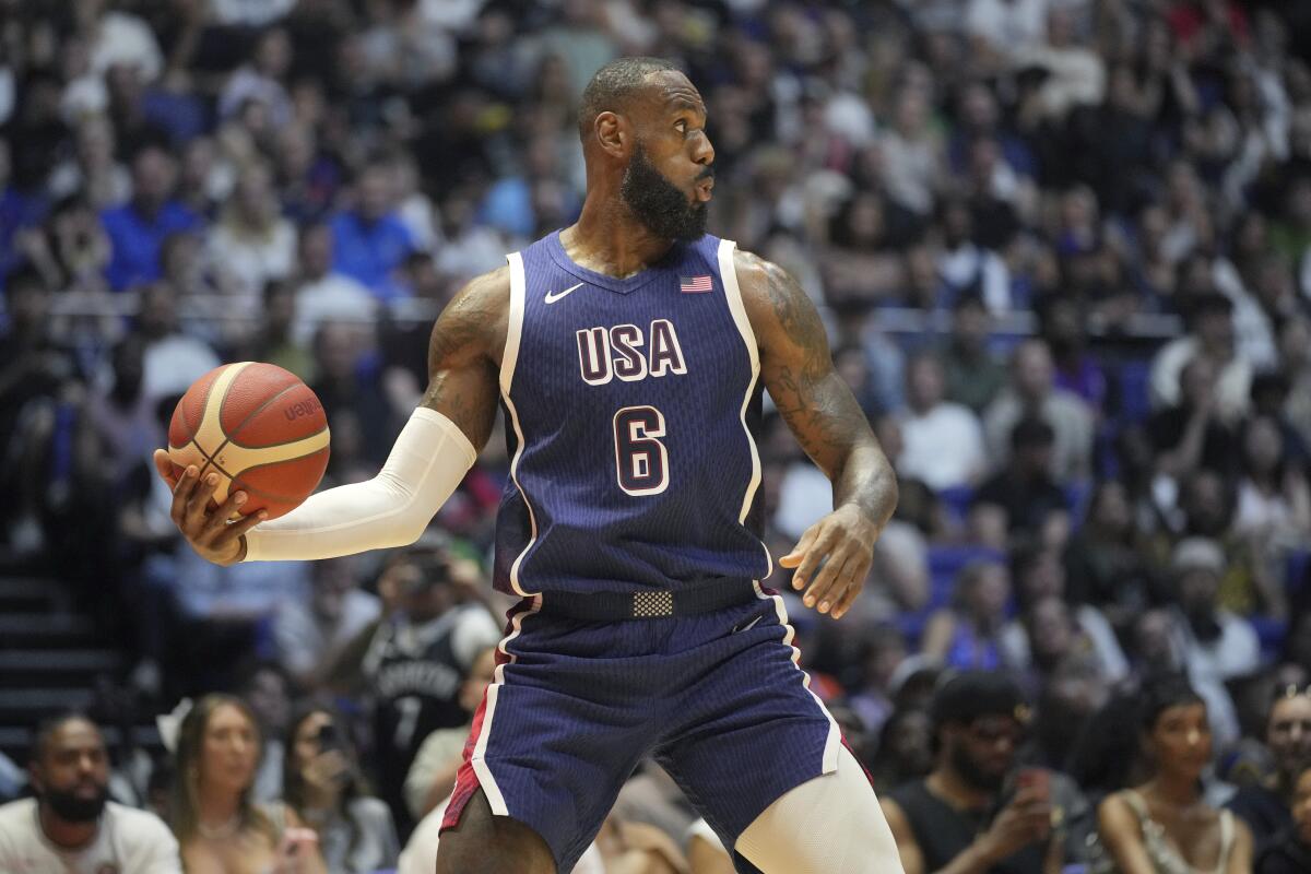 LeBron James looks to pass the ball during an exhibition basketball game.