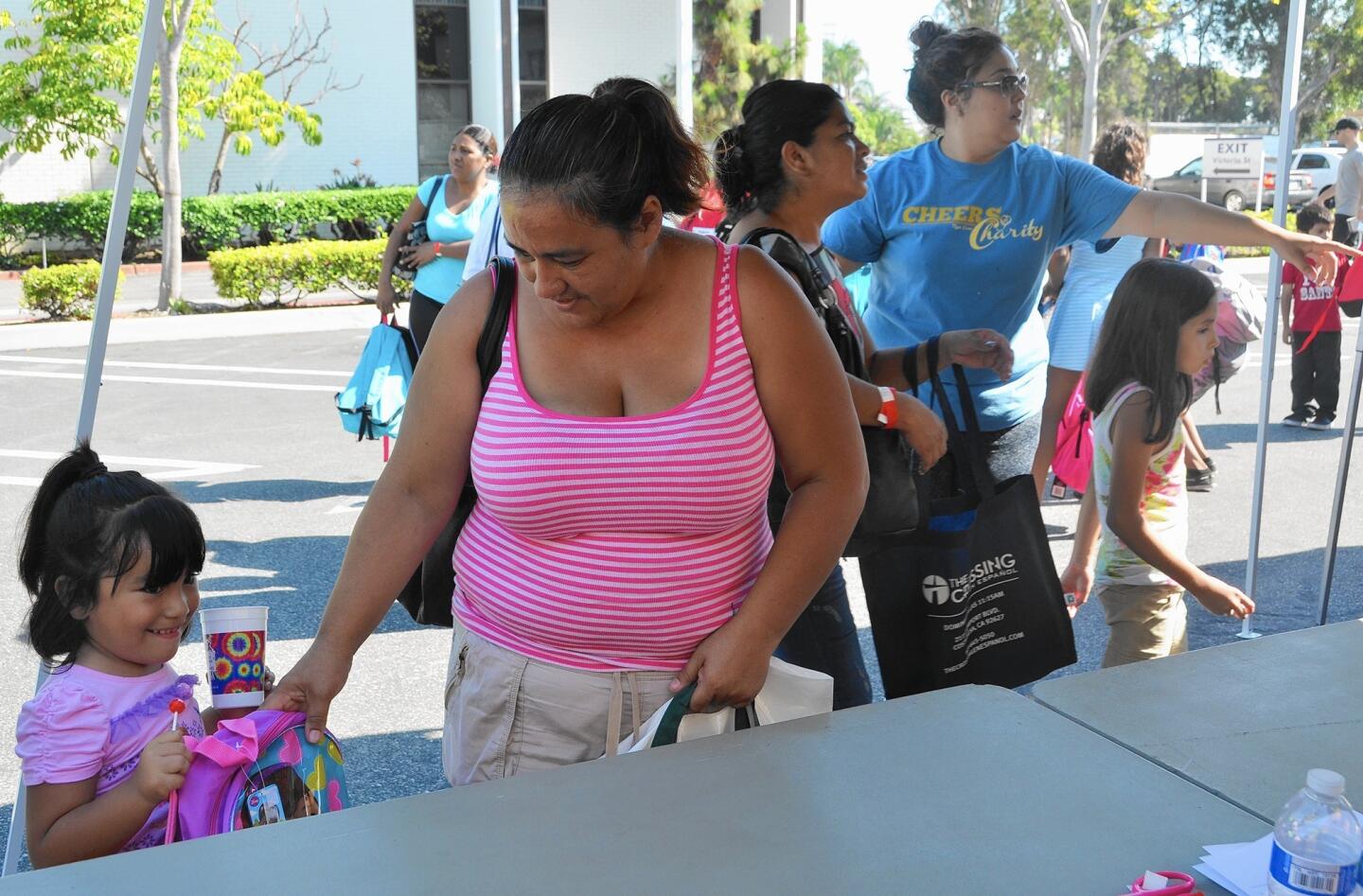 Families attend Share Our Selves' 20th annual Back to School event on Saturday, which provided about 3,800 local students from low-income families with backpacks and school supplies.