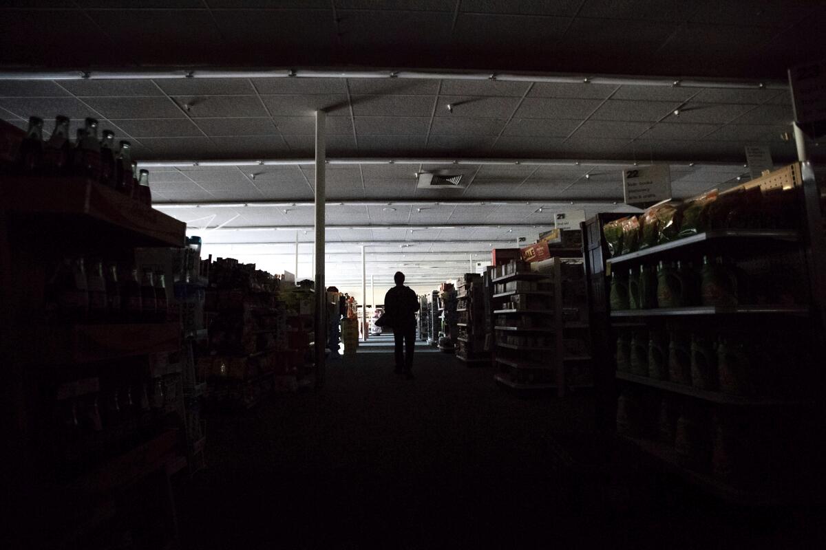 Shift supervisor James Quinn walks through a darkened CVS store during the power outage