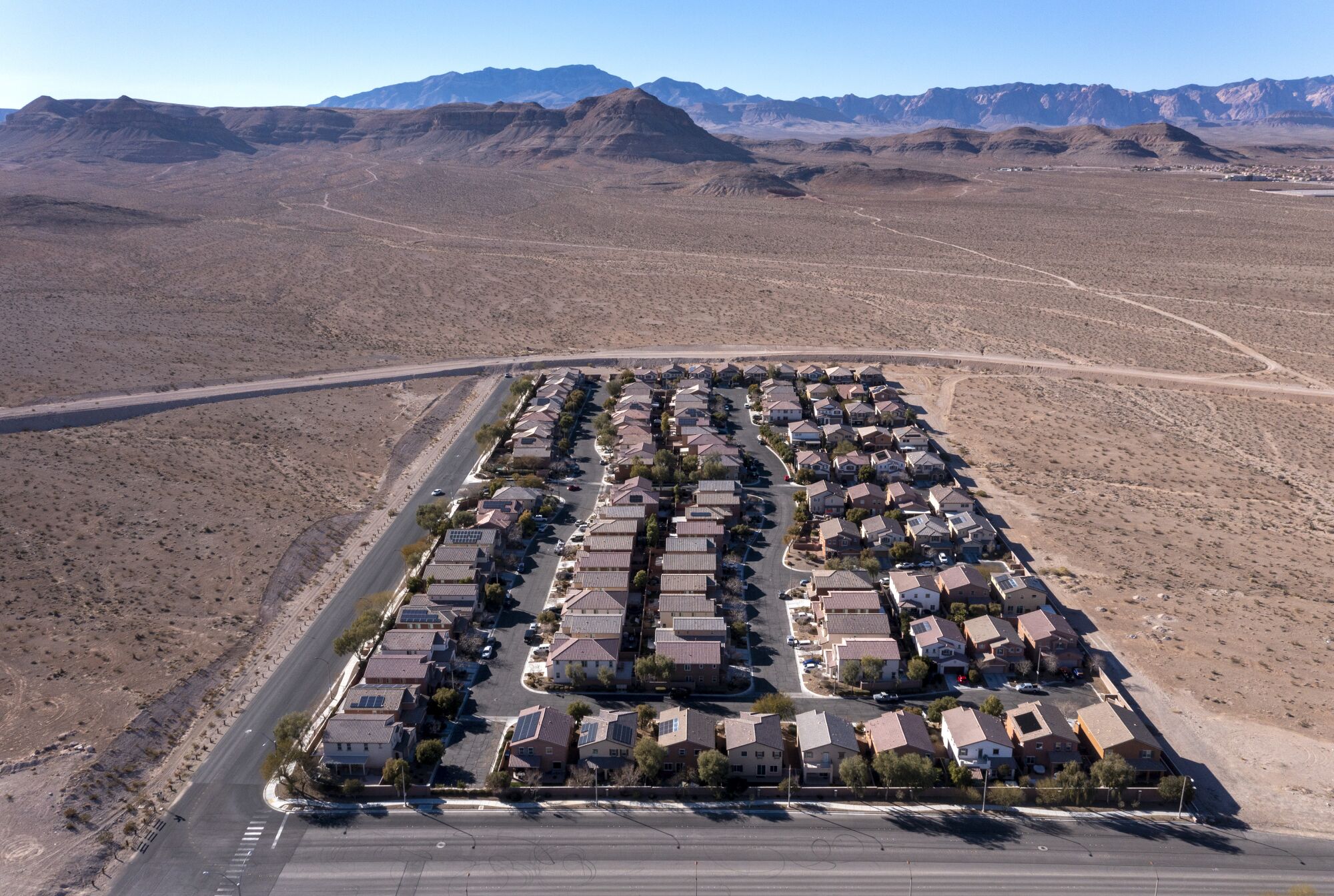 An aerial scene of a rectangular residential area surrounded by a vast desert