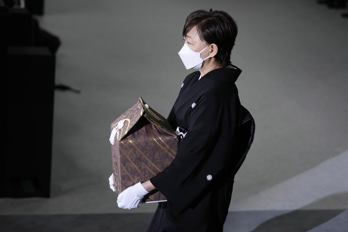 Widow of former Japanese Prime Minister Shinzo Abe carrying urn with his ashes