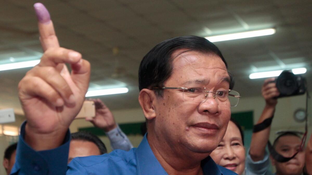 Cambodian Prime Minister Hun Sen shows off his inked finger after voting in a local election June 4 in Cambodia's Kandal province.