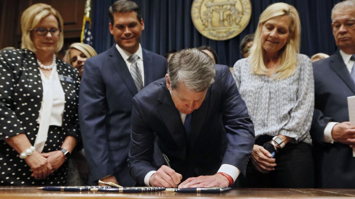Georgia's Republican Gov. Brian Kemp, center, signs legislation on May 7 to ban abortions once a fetal heartbeat can be detected.