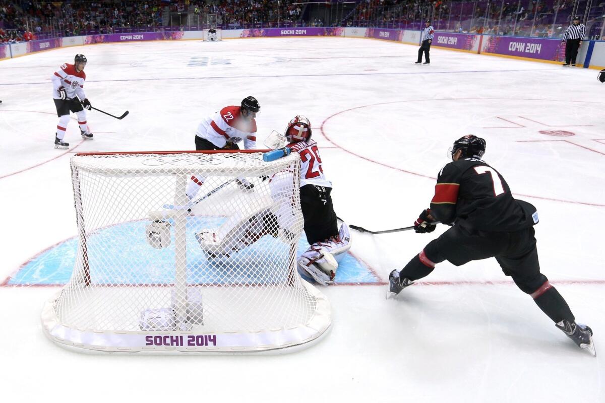 Jeff Carter, right, scores a second-period goal against goalie Bernhard Starkbaum, center, during Canada's 6-0 blowout of Austria during group play Friday. Carter had three goals in the victory.